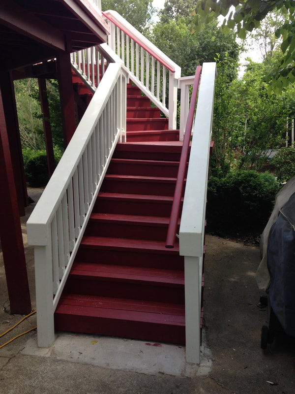 Picture of the new stairs and railing that the painter had installed and painted red with white rails. 