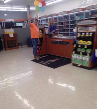 Picture of owner in Sherwin Williams Store in Grand Blanc at the counter with the  Manager both waving hello.